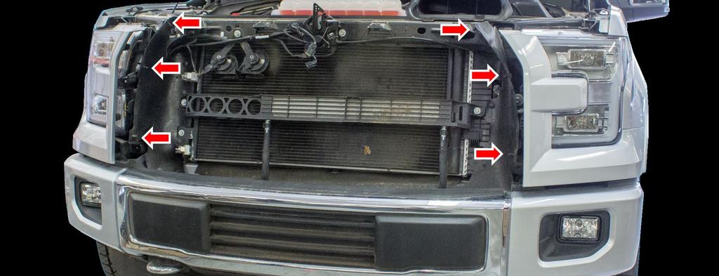 7. Remove the plastic clips that hold the rubber shroud to the grille (3 per side), then lift
