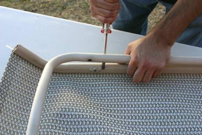 Insert the flat head screw driver in between the frame and the loose rail of the chaise back.