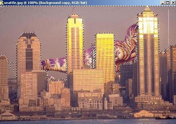 8. Relocate dinosaur behind buildings: Click on the background copy of Seattle. Select Magic Wand Tool. Hold down Shift Key and select all of sky above the buildings.
