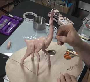 Use a hobby knife with a straight blade to whittle the clay so the legs are a uniform thickness. Add some fashioned clay to suggest the thigh muscles and blend them into the body.