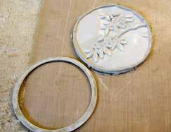 Using the same circle template used to cut the outer circle of the frame, cut out a circle around the design [6]. Allow the clay to dry to a semi-dry state.