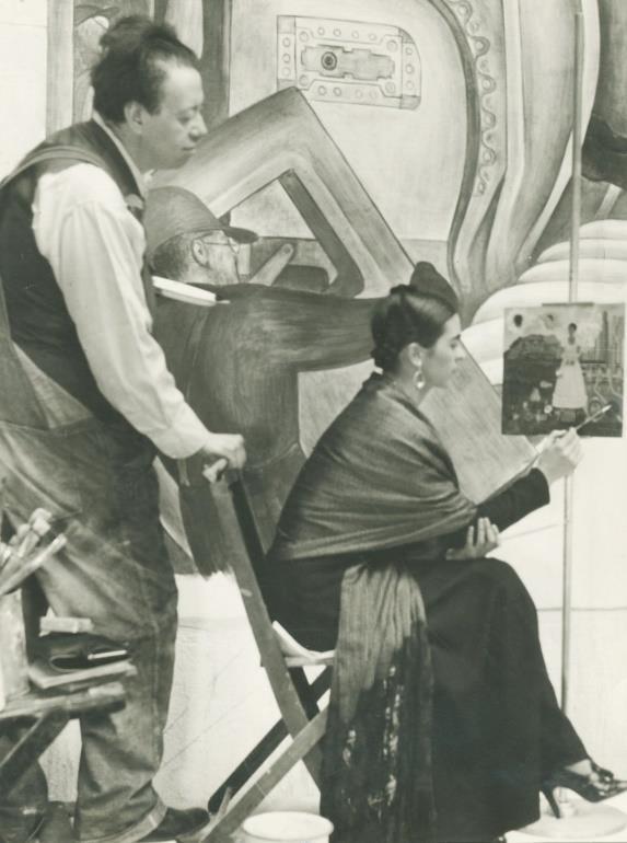 Title: Diego Observing Frida Paint Her Self-Portrait On The Borderline, Detroit Date of Creation: 1932 Artist/Designer: Unknown Nationality of Artist/Designer: Unknown Material/Medium: Gelatin Silver