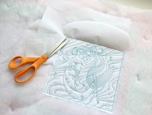After the embroidery is done stitching, use a scissor to trim away the extra stabilizer on the backside of the design.