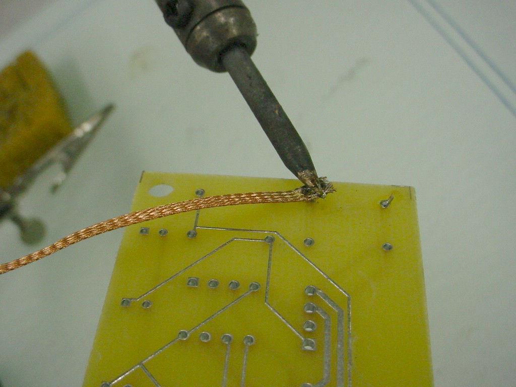 on the solder to be removed Heat the wick to melt and draw the solder into the
