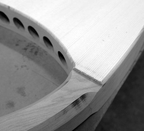When we position the soundboard, we like to have the top edges of the spruce lined up just above where the soundhole arch meets each side piece, as