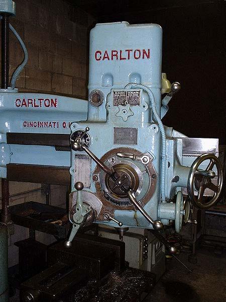 Radial arm drill press Radial arm drill press controls A radial arm drill press is a large geared head drill press in which the head can be moved along an arm that radiates from the machine's column.