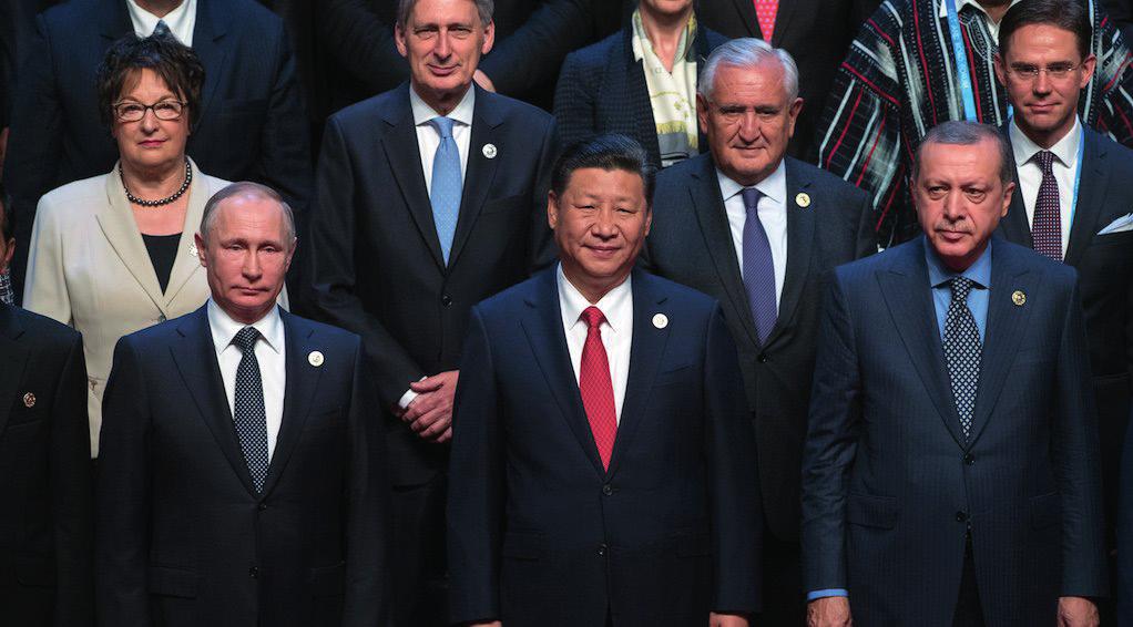 Chinese President Xi Jinping with Russian President Vladimir Putin and his Turkish counterpart Recep Tayyip Erdogan; standing behind them is the former French Prime Minister Jean-Pierre Raffarin, the