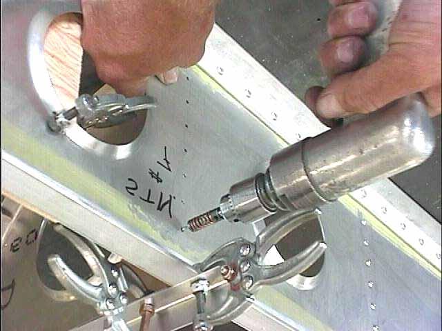 Sight through the holes in the spar, align the center line marked on the rib with the holes. file V-42 Photo V4-7 First drill the hole closest to the bench top with a 3/32 drill.