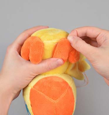 Hold the feet in place by sticking pins into the base of the foot through the body of the plush. b. Ladder stitch the feet in place similar to how you did back in step 19.