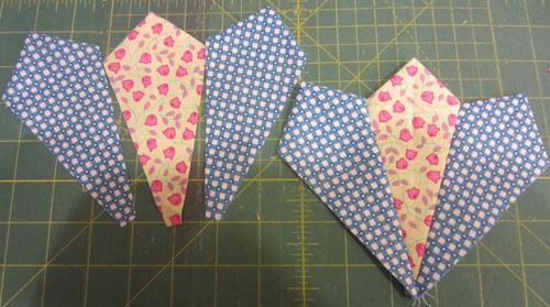 Fold one section in half. Sew across the straight end. Flatten into kite shape.