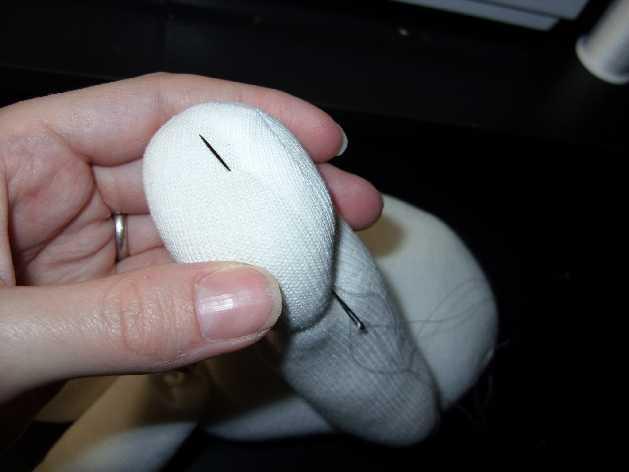 Once you have blind stitched across the top of the foot, knot to hold with a quilting knot, then insert the needle back in at the knot, coming out at the bottom of where the first toe will