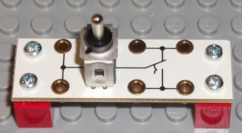 This is a toggle switch Examples: light switch, On-Off Switches for electrical devices.