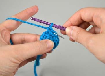 Draw the yarn through the stitch and up into the working area. You should now have two loops on the hook.