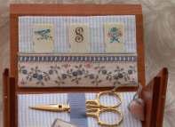 Smalls include a needlebook, pynkeep, and berry scissors ornament. Stitches include hem stitching, long-arm cross, overlap stitch, stem stitch, tent stitch, and cross stitch over one.