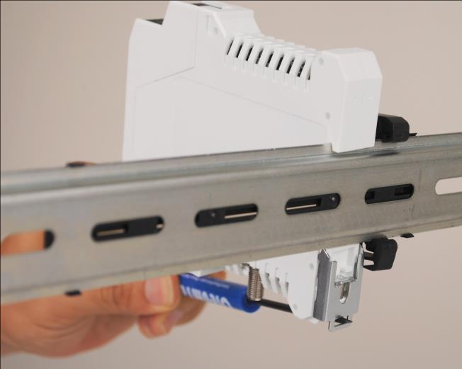 removed from the din rail by inserting the tip of a