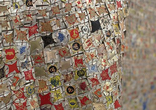 El Anatsui is an internationally acclaimed artist who transforms simple materials into complex assemblages that create distinctive visual impact.