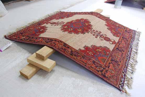 In the picture above, the rug is being stretched to remove wrinkles.
