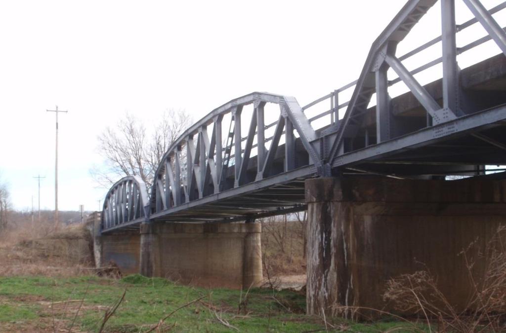 bridge is 22.3 feet measured from center-to-center of the trusses. The maximum height of the trusses is 14 feet at the midspan point.