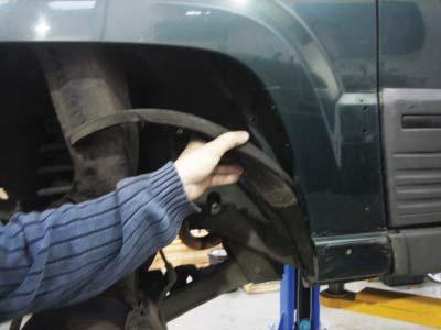 Pull the splash shield away from rear area of the fender and tuck it into the spring.