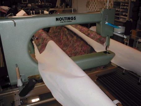 INSTRUCTIONS FOR LOADING A QUILT ON YOUR NOLTING LONGARM MACHINE ATTACHING LINER TO MACHINE ROLLERS Place liner (backing fabric) in CENTER AREA of the table with WRONG side up, draping liner fabric