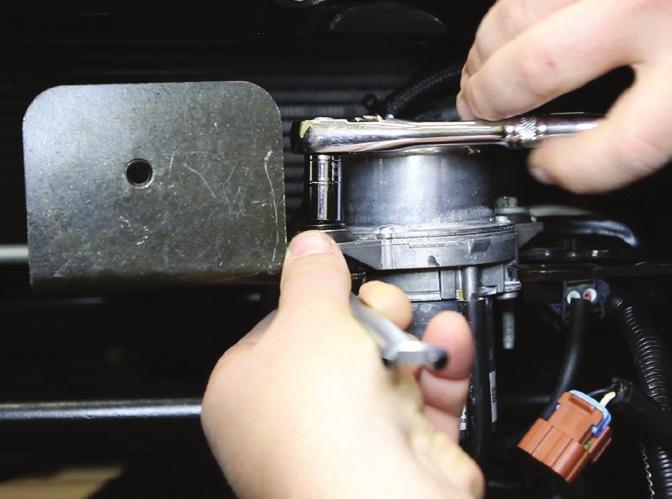 Swing the vacuum pump toward the rear of the vehicle and snug the rear bolt, but do not fully