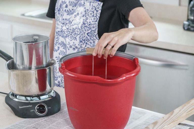 Smoothly and slowly pull the wick out of the wax and dip in the bucket of cool water.