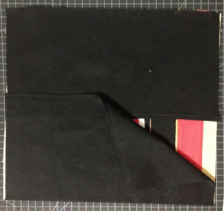 the front piece with the folded seam toward the bottom. Follow by placing the other back piece on top of the last, aligning with the bottom of the front piece.