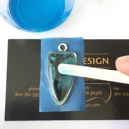 Use a toothpick to drag the resin to the outside edges of the bezel.