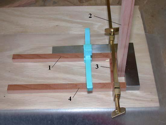 Once you have a piece of the correct length, cut three more just like it. Lay a piece of waxed paper on a flat surface. On this, clamp one of the uprights against a square (1 in the photo below).