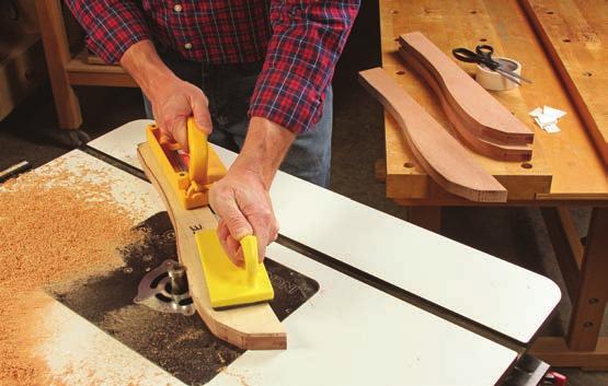 Secure the seat rail template to a workpiece with strips of double-sided tape, and shave the rough edges flush to the template using a bearing-guided flush-trim bit at the router table.