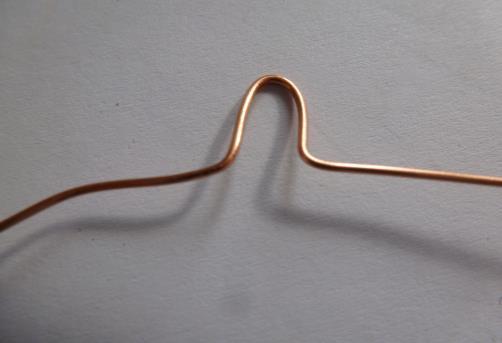 Step 2: In the middle of your twenty four inches of wire, make a mark and then make a loop like this (around a pen, tool, etc) You