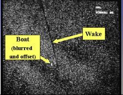 Figure 2. Moving Boat Appears Displaced From its Actual Position in a SAR Image (Source: www.sandia.gov) II.