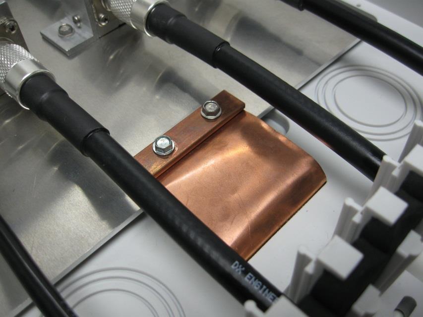 Figure 1, note the alignment of the coaxial cable, suppressors and access holes are in a fairly straight line. Some types of coaxial cable are not very flexible and sharp bends should be avoided.