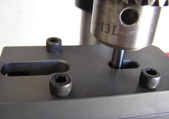 After the area in front on the jig bolt is milled, unscrew and slide out the jig bolt and use the same process used to stabilize the jig that was used when drilling the red 1/8 holes by inserting a