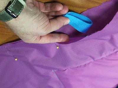Fold the strapping into loops and insert them between the fabric layers of the bag about 2" up from the bottom fold.