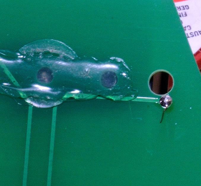 Using a hot iron (circa 400C) solder the wire to the pad - it is self-fluxing wire, so no scraping or stripping is needed, but try not to inhale the fumes.