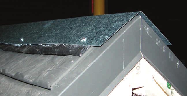Press firmly to both sides of the ridge in order to make the glue stick to the top of the last row of shingle panels.