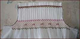 Stitch in place -Using binding, press under ¼ on both long sides of binding -Line up fold of binding with top row of smocking (or piping, if piping was used)