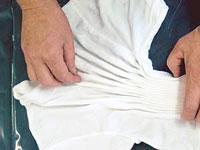 Continue pinching folds across the shirt, straighten the pleats as you go by pulling at the
