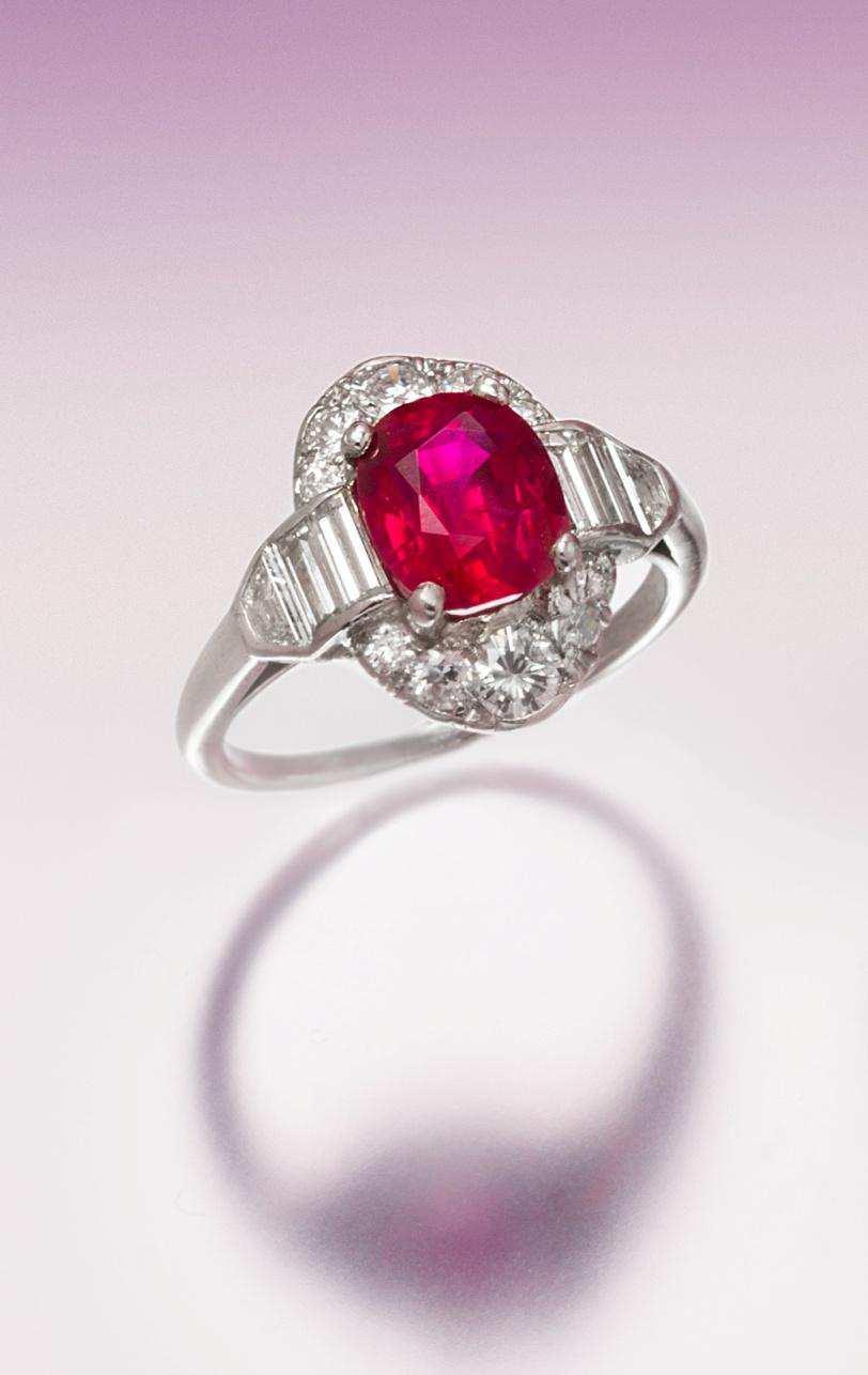 Lot 469 An Art Deco Platinum, Burmese Ruby and Diamond Ring, containing one oval mixed cut ruby weighing approximately 2.