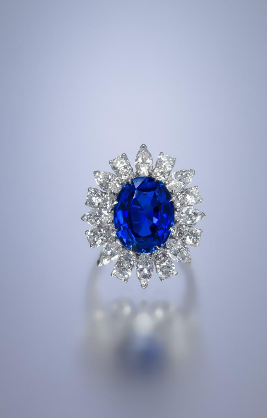 Lot 410 A Fine Platinum, Burmese Sapphire and Diamond Ring, French, containing one oval mixed cut sapphire weighing approximately 8.56 carats, 16 round brilliant cut diamonds weighing approximately 1.