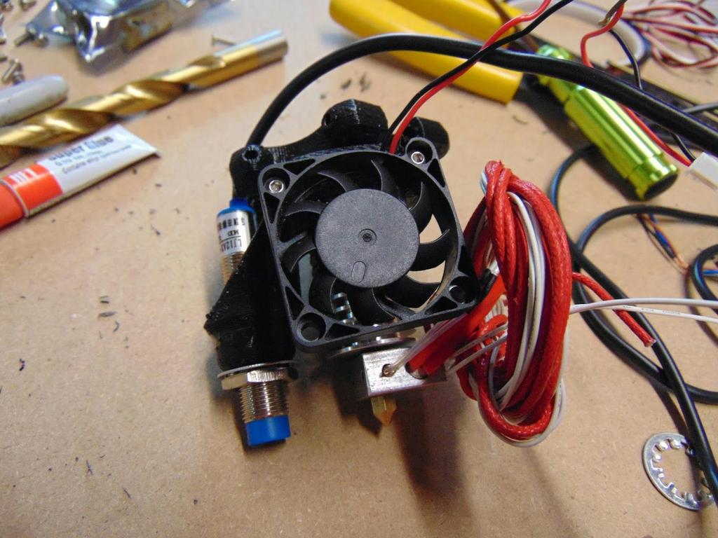 Using 2 M3x12 bolts, mount the Cooling Fan to the Hot End mount so the wires are at the top.
