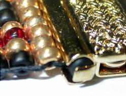 the clasp to capture the first row of beads and the extra black seeds inside