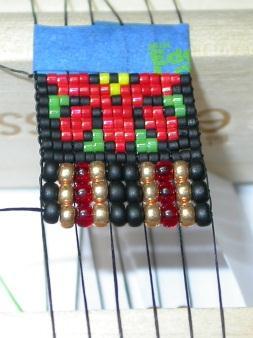 25 String and weave a size 8 seed bead row: black, gold, red, gold, 2 black, gold,