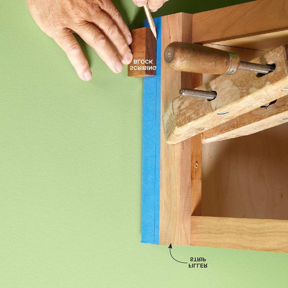 Hold a level across the wall, and slide a shim up from the bottom (go in from the top when you're doing the top side) until it's snug. Then pin or tape it into place.