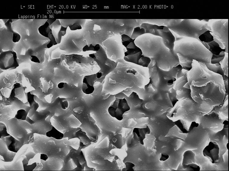 The larger sizes of SiC grits are clearly identified in Fig. 2. The submicro alumina and diamond abrasives are shown in grit clusters in Fig. 2..1 µm Diamond.5 µm Alumina Fig. 2. SEM micrographs of the polishing films.