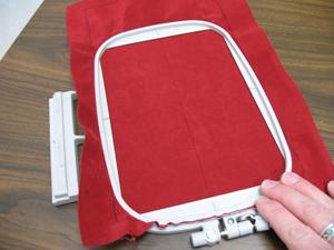 Spray a piece of cutaway stabilizer with adhesive and smooth the fabric on top.