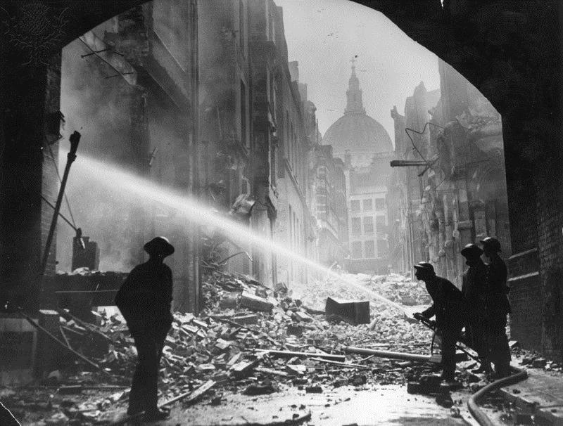 Picture 15 Firemen tackle a fire amidst the rubble surrounding St Paul's Cathedral.