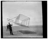 of glider flying as a kite near the ground, Wilbur at left and Orville at right, glider turned forward to right and