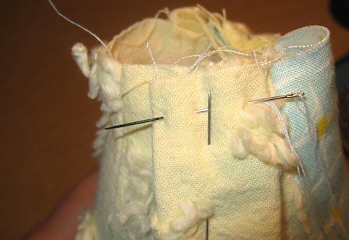 15. Set the head back into position on the body, tucking the in the raw edges. Pin in position. You can pin to a certain extent, but you'll have to hold the head with one hand as you stitch. 16.